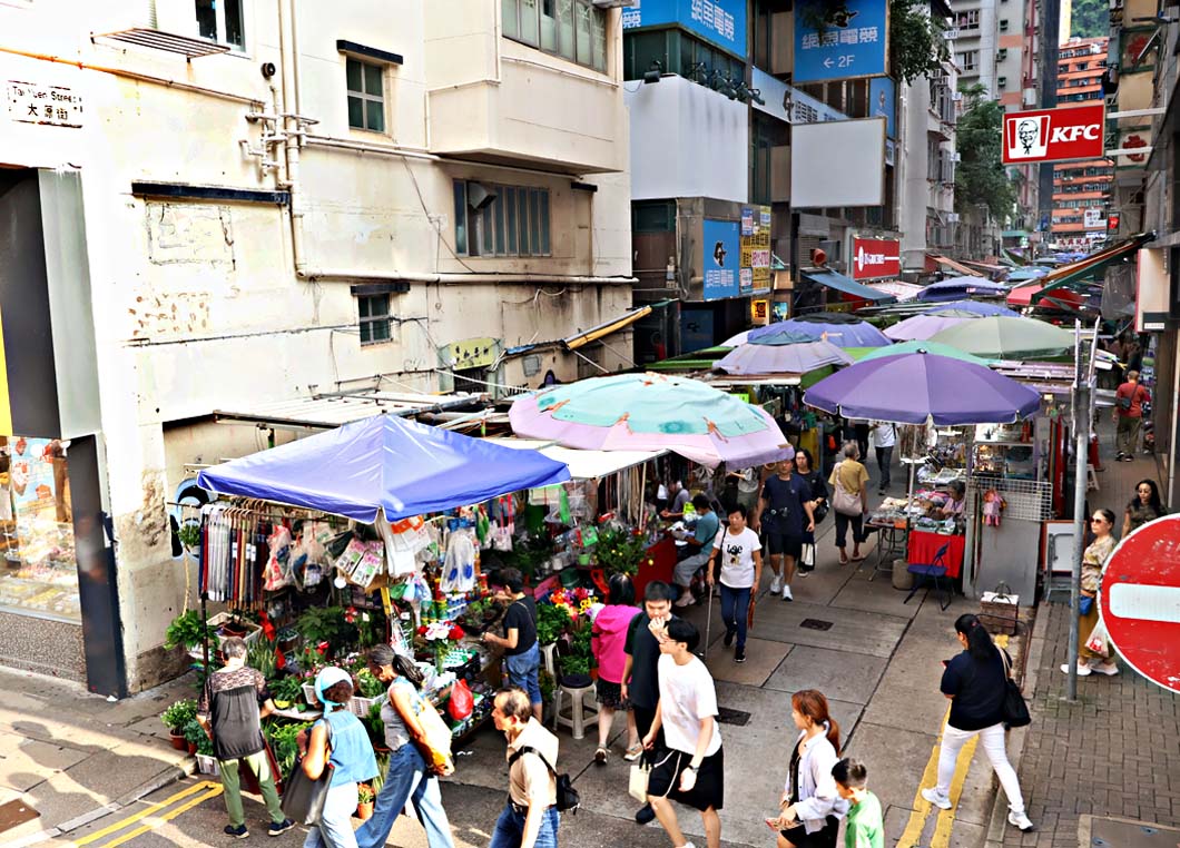 灣仔太原街市集俯視：彩色遮傘、花檔與行人，遠處可見KFC招牌